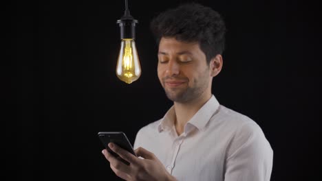 The-man-looking-at-the-phone-has-a-new-idea-and-the-lamp-turns-on.-Eureka